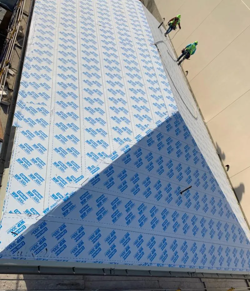 Professional roofers installing underlayment on a metal roof in West Hattiesburg